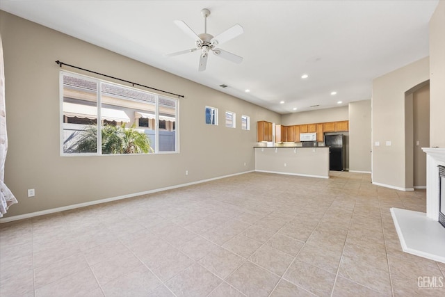 unfurnished living room featuring ceiling fan and light tile patterned flooring