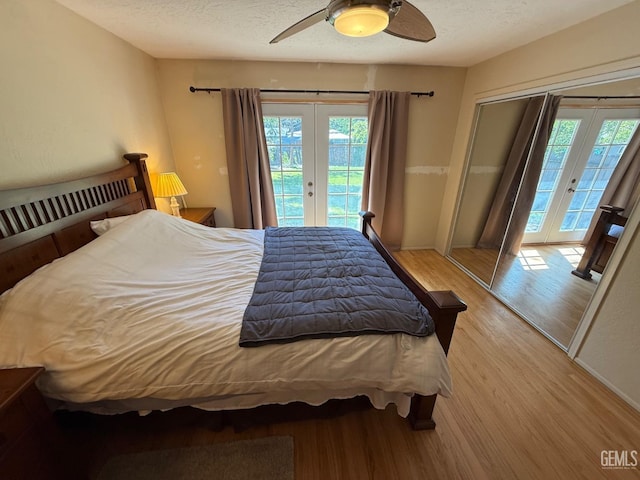 bedroom with french doors, wood finished floors, access to outside, and multiple windows