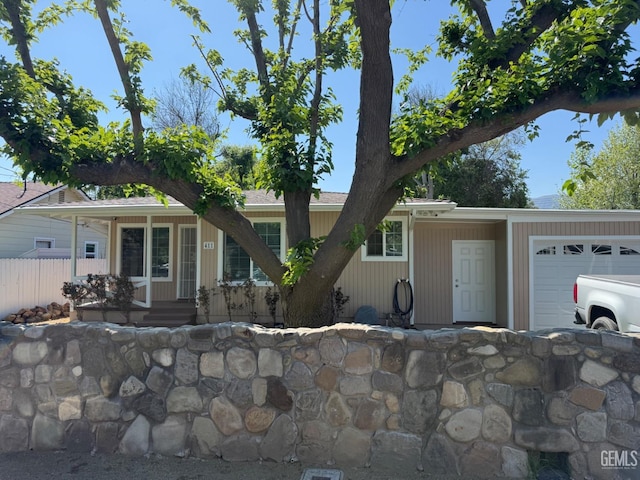 view of front of property featuring a garage and fence