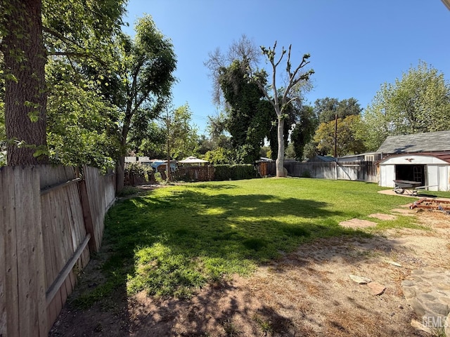 view of yard featuring a fenced backyard, an outbuilding, and a storage shed