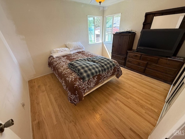 bedroom with baseboards and wood finished floors