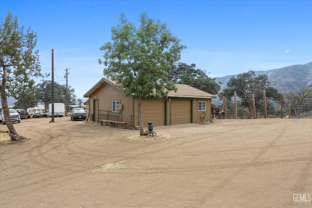 exterior space with a garage, an outbuilding, and a mountain view