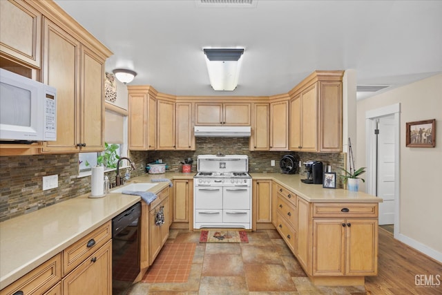 kitchen featuring white appliances, a sink, light countertops, under cabinet range hood, and backsplash