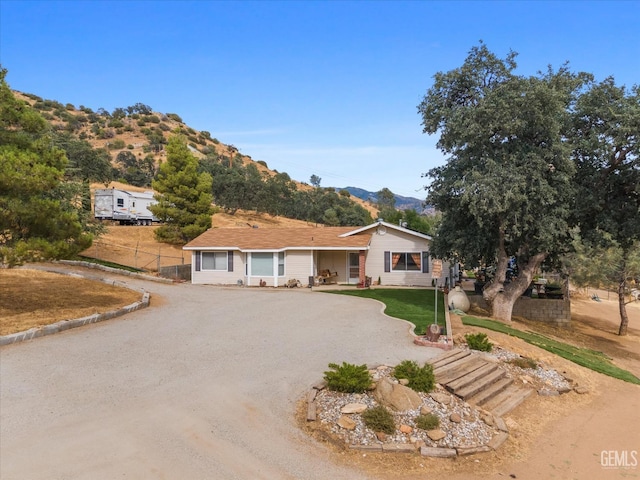 single story home with driveway and a mountain view