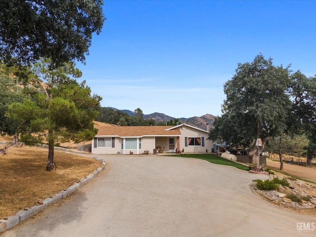 single story home featuring dirt driveway and a mountain view