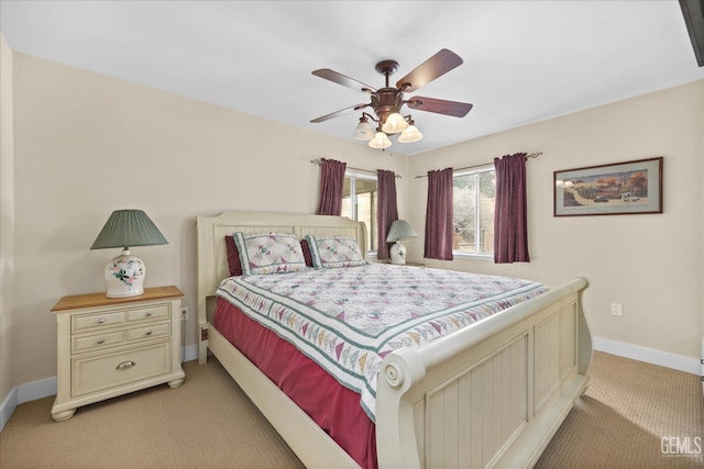 bedroom with a ceiling fan, light colored carpet, and baseboards