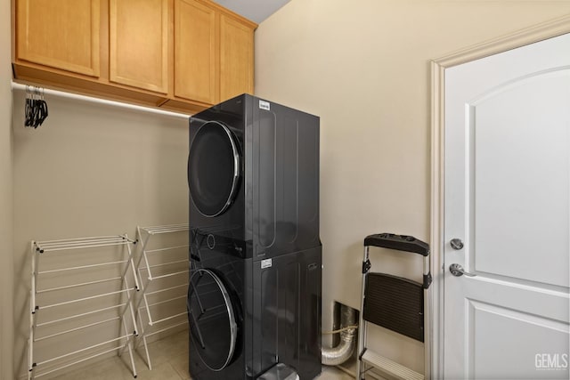 11901 Kimelford Dr, Bakersfield, CA 93312 - washroom featuring stacked washer and clothes dryer, cabinet space, and light tile patterned floors