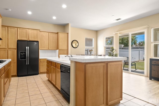 11901 Kimelford Dr, Bakersfield, CA 93312 - kitchen with black appliances, light brown cabinetry, light tile patterned flooring, tile counters, and a center island with sink