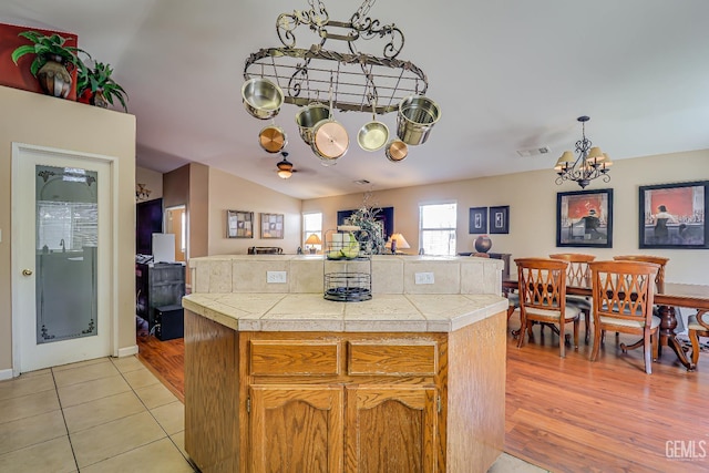10126 Pyramid Peak Dr, Bakersfield, CA 93311 - kitchen with a chandelier, a center island, light tile patterned floors, and pendant lighting