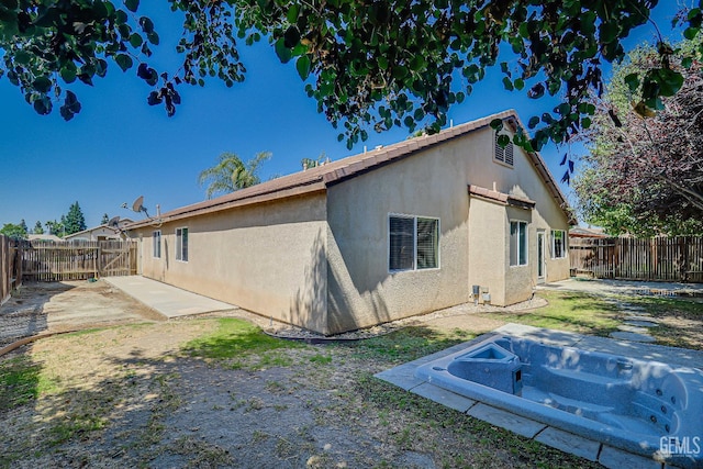 10126 Pyramid Peak Dr, Bakersfield, CA 93311 - back of property with stucco siding, a patio area, and a fenced backyard