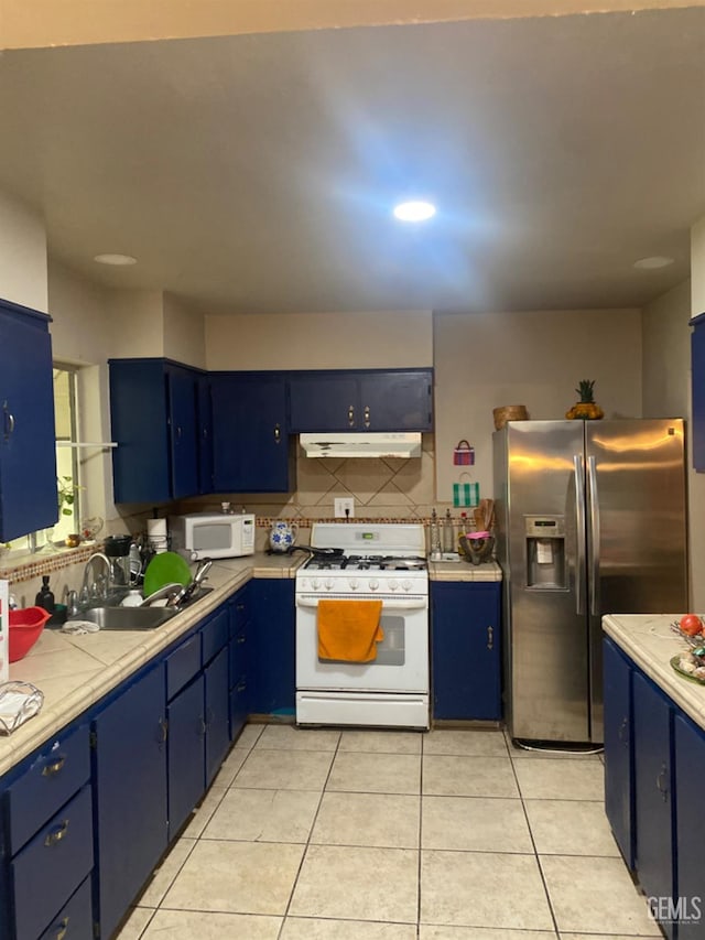 kitchen featuring sink, tasteful backsplash, blue cabinets, white appliances, and light tile patterned floors