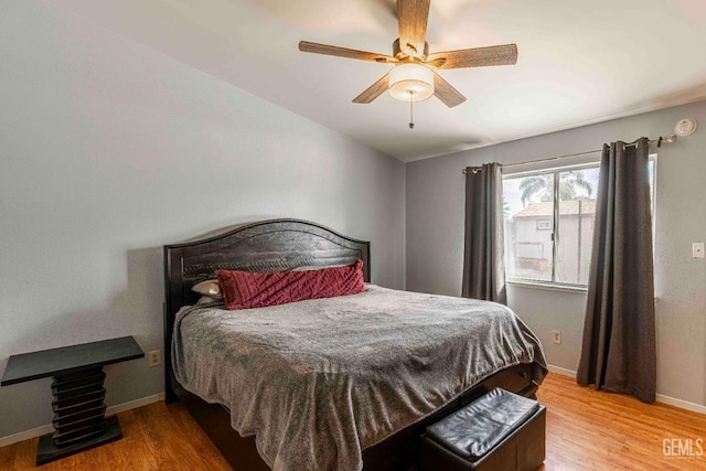 bedroom featuring a ceiling fan, wood finished floors, and baseboards