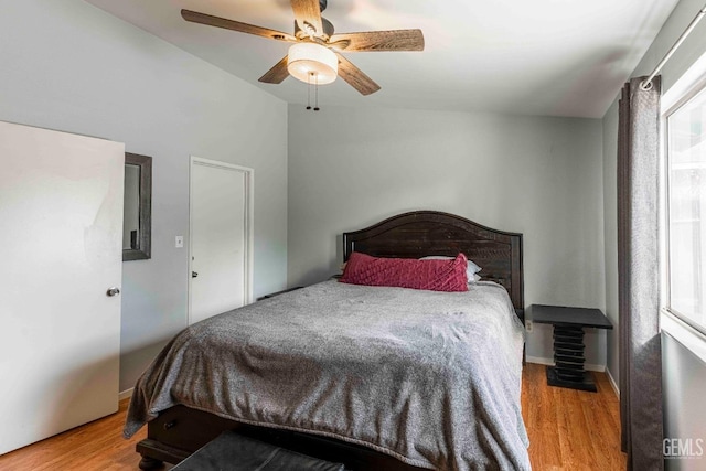 bedroom featuring ceiling fan, baseboards, lofted ceiling, and wood finished floors