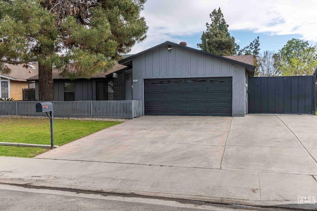 single story home featuring driveway, a front yard, a garage, and fence