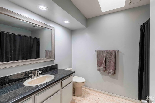 full bathroom featuring a skylight, recessed lighting, toilet, and vanity