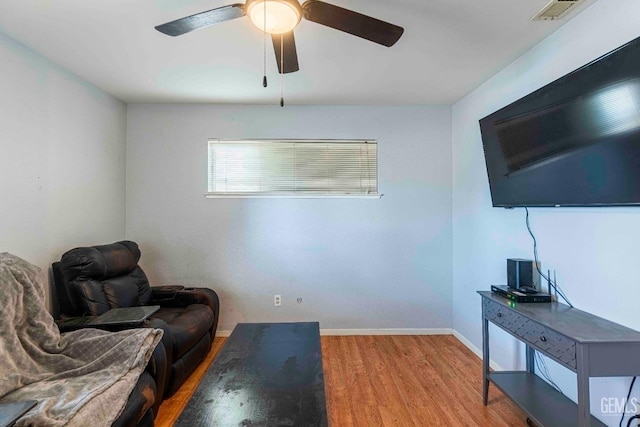 living area with visible vents, baseboards, and wood finished floors