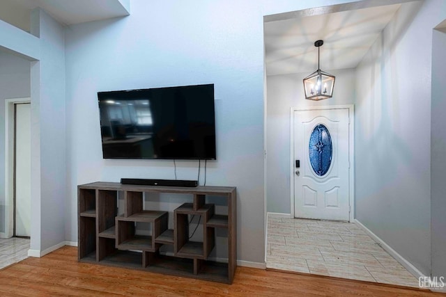 foyer entrance with baseboards and wood finished floors