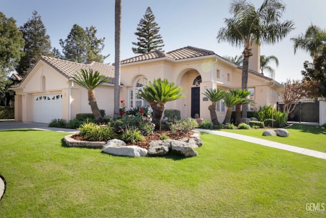 mediterranean / spanish-style house featuring a garage and a front yard