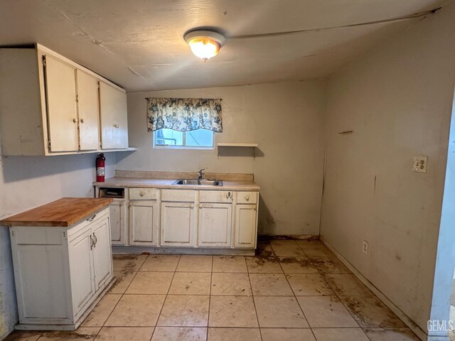 1509 Penny St, Bakersfield, CA 93306 - kitchen with wooden counters, open shelves, light tile patterned floors, and white cabinetry