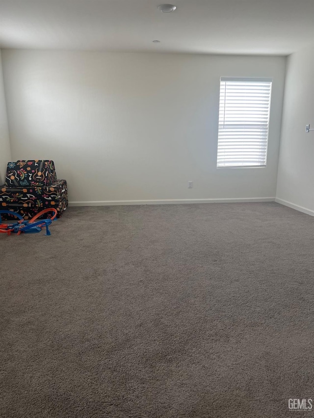 carpeted spare room featuring baseboards