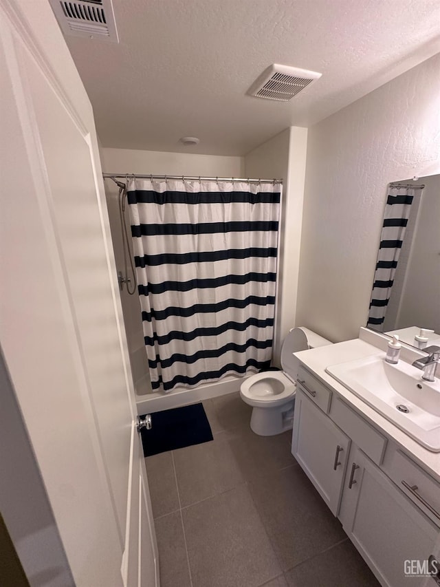 full bathroom featuring a textured ceiling, toilet, vanity, and visible vents