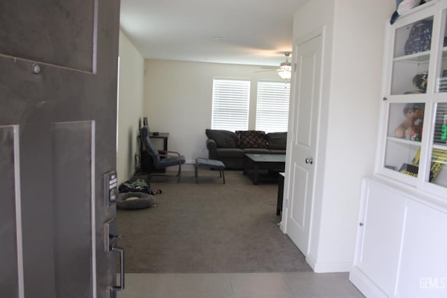 interior space featuring light carpet, light tile patterned floors, and a ceiling fan