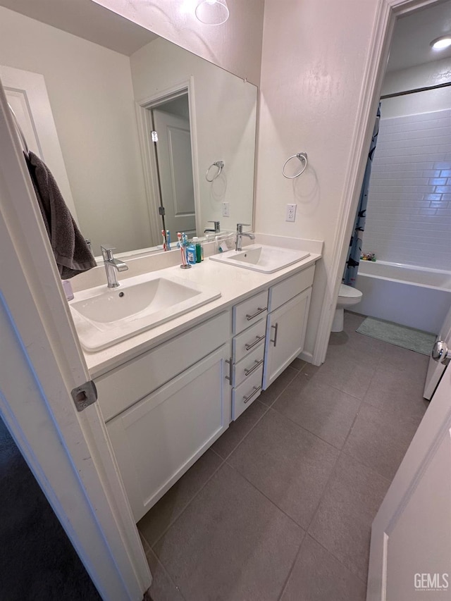 full bathroom featuring double vanity, toilet, a sink, and tile patterned floors