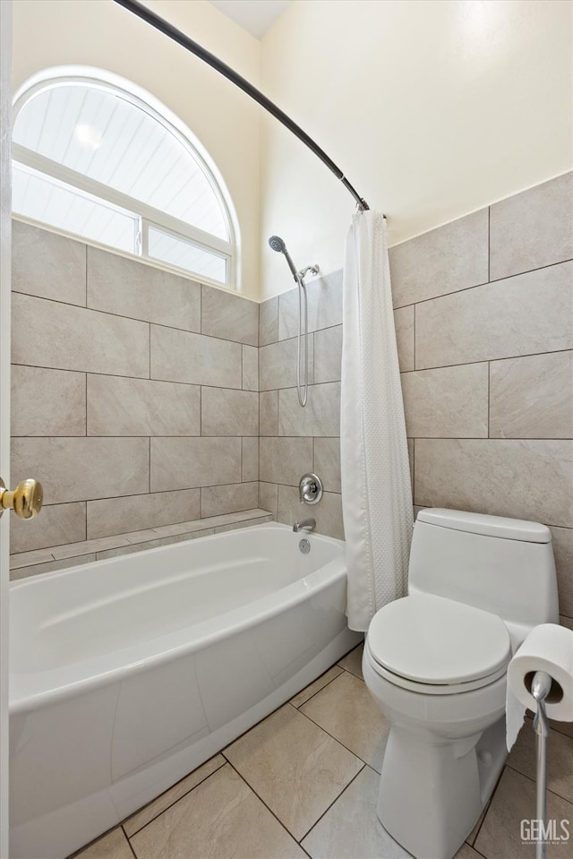 bathroom featuring shower / bath combo with shower curtain, tile patterned floors, toilet, and tile walls