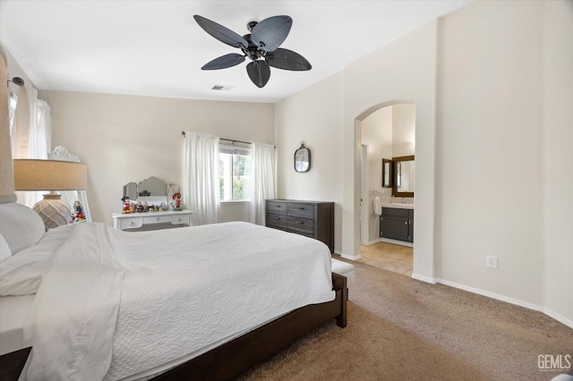 carpeted bedroom featuring lofted ceiling, connected bathroom, and ceiling fan