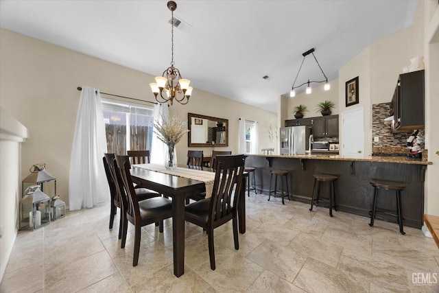 dining area with vaulted ceiling and a notable chandelier