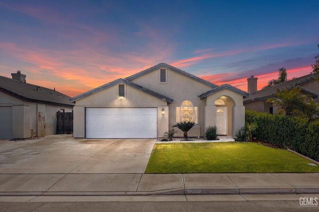 view of front of property with a garage and a yard