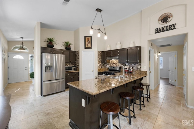 kitchen with tasteful backsplash, dark brown cabinetry, stainless steel appliances, and sink