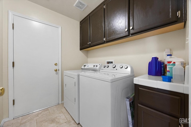 laundry area featuring cabinets and washing machine and dryer