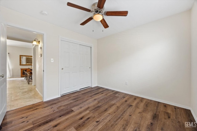 unfurnished bedroom featuring a closet, dark hardwood / wood-style floors, and ceiling fan