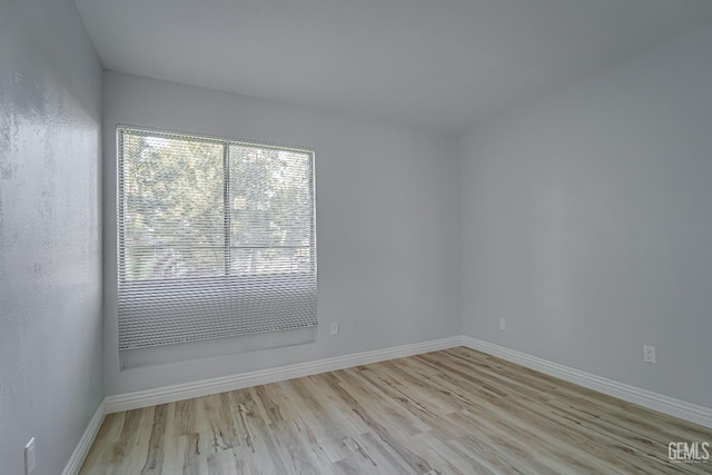 empty room with baseboards and wood finished floors