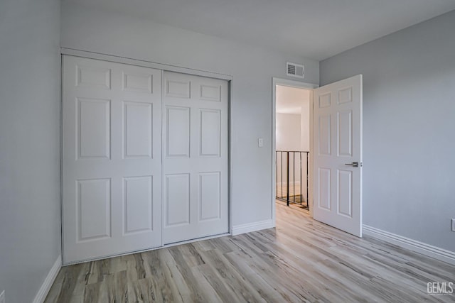 unfurnished bedroom featuring baseboards, visible vents, and wood finished floors