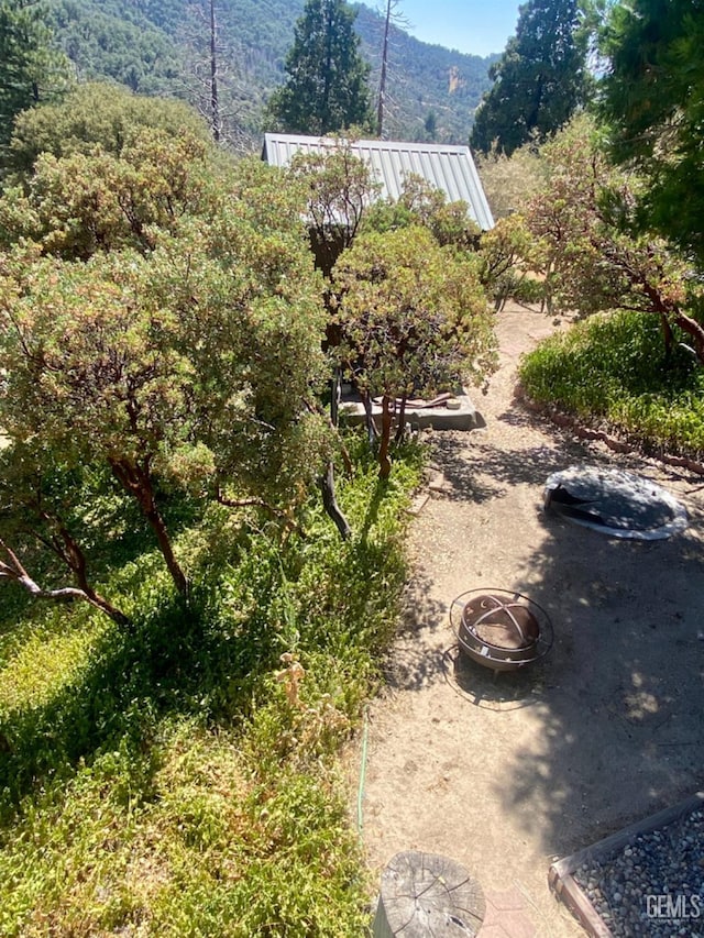 view of yard featuring a mountain view and an outdoor fire pit