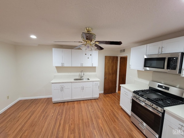 6918 Crestwood St, Bakersfield, CA 93308 - kitchen featuring stainless steel appliances, ceiling fan, light countertops, white cabinets, and recessed lighting