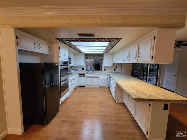 6918 Crestwood St, Bakersfield, CA 93308 - kitchen featuring freestanding refrigerator, a peninsula, light wood-style flooring, and white cabinets