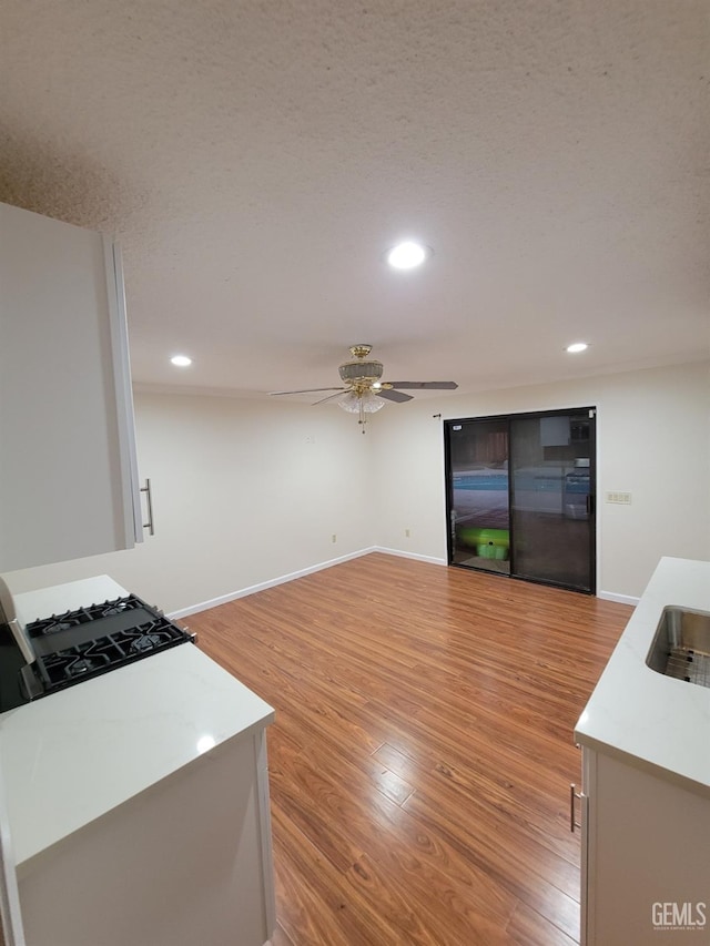 6918 Crestwood St, Bakersfield, CA 93308 - kitchen with ceiling fan, light wood-style floors, light countertops, recessed lighting, and range