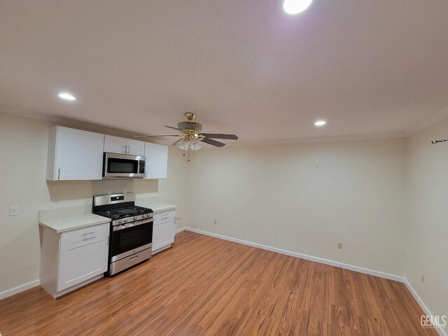 6918 Crestwood St, Bakersfield, CA 93308 - kitchen with stainless steel appliances, ceiling fan, light countertops, light wood-type flooring, and white cabinetry