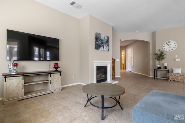 5703 Park Pl, Bakersfield, CA 93306 - living room featuring arched walkways, light tile patterned floors, and a glass covered fireplace