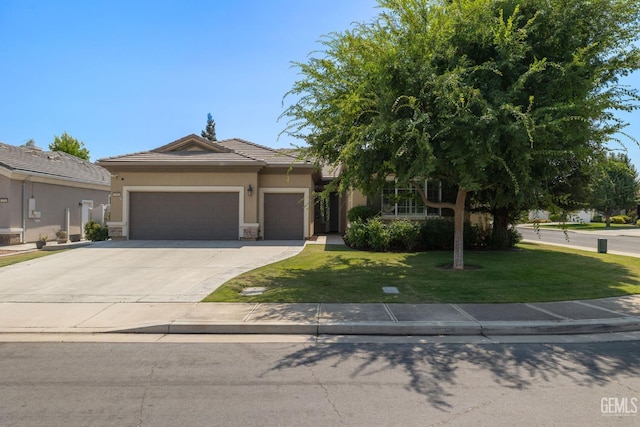 5703 Park Pl, Bakersfield, CA 93306 - view of front of house featuring an attached garage, a front yard, driveway, a tiled roof, and stucco siding