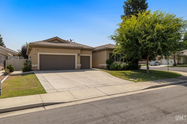 5703 Park Pl, Bakersfield, CA 93306 - view of front of house featuring an attached garage, stucco siding, stone siding, concrete driveway, and a tiled roof