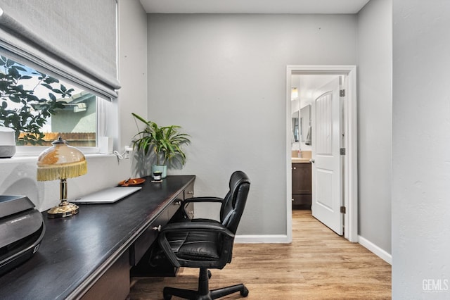 office featuring light wood-type flooring and baseboards