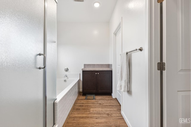 full bathroom with wood finished floors, a shower stall, and a bath