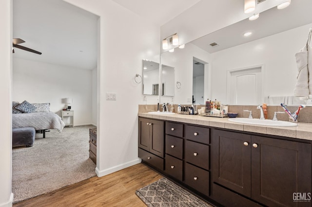 ensuite bathroom featuring double vanity, wood finished floors, ensuite bathroom, and a sink