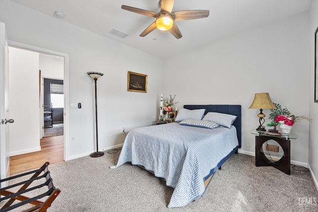 carpeted bedroom featuring baseboards, visible vents, and ceiling fan