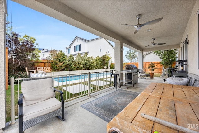 view of patio with ceiling fan, a fenced in pool, a fenced backyard, and grilling area