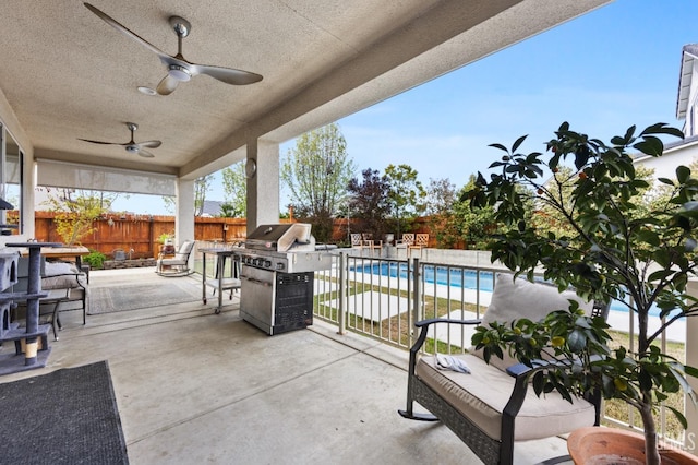 view of patio with area for grilling, a fenced in pool, a fenced backyard, and ceiling fan